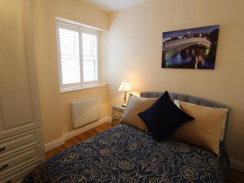 a bedroom with a bed with pillows and a window at Garda House in Kinsale