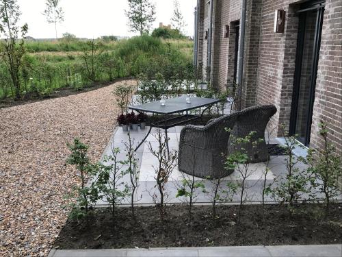a patio with a table and chairs on the side of a building at KerkHotel Biervliet in Biervliet