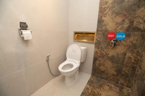 a bathroom with a white toilet in a stall at Villa White House Batu in Batu
