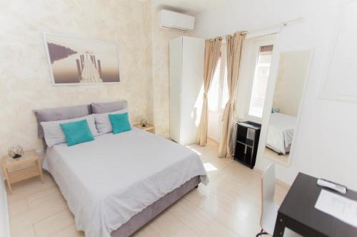 1 dormitorio con cama con almohadas azules y escritorio en San Pietro Home, en Roma