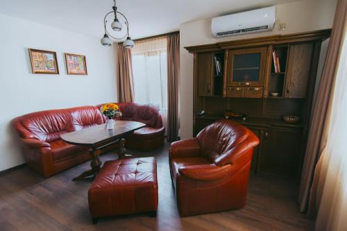 een woonkamer met lederen meubels en een tafel en stoelen bij RELAX Apartments in HASKOVO, Apt1 in Haskovo