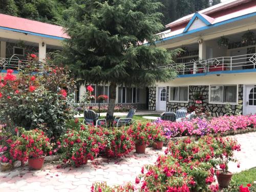 a garden of flowers in front of a building at Parhena Cottages Bella Naran in Nārān