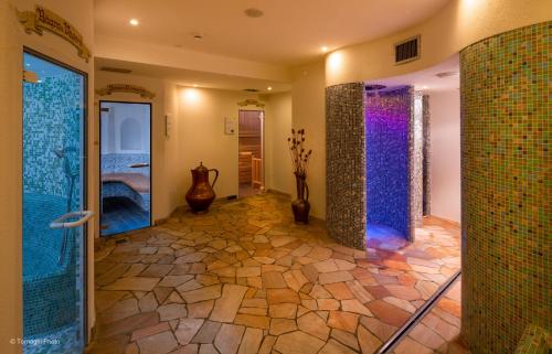 a bathroom with a walk in shower and a glass door at Hotel Alpen in Andalo