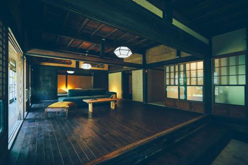 a living room with a couch and a table at Kominkayado LOOF Sannoie in Koike