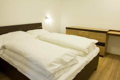 an unmade bed with white pillows on top of it at Apartmány Valča in Valča