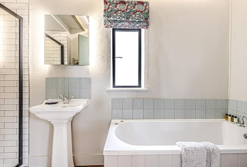 a bathroom with a white tub and a sink at Loaf in Bridport
