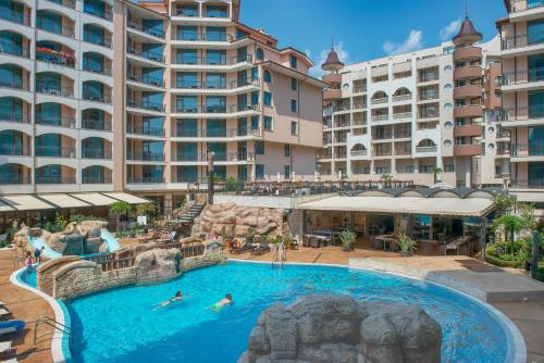 una piscina al aire libre en un complejo con personas nadando en él en South Beach Vacation Apartments, en Sunny Beach