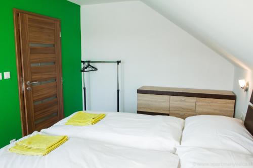 a bedroom with a bed with two yellow towels on it at Apartmány Valča in Valča