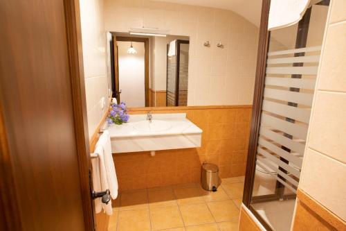 Hostal Rural Zahara في زاهارا دي لا سييرا: حمام مع حوض ومرآة
