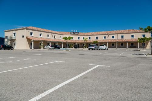 an empty parking lot in front of a building at Le Ya'Tis in Saint-Laurent-des-Arbres