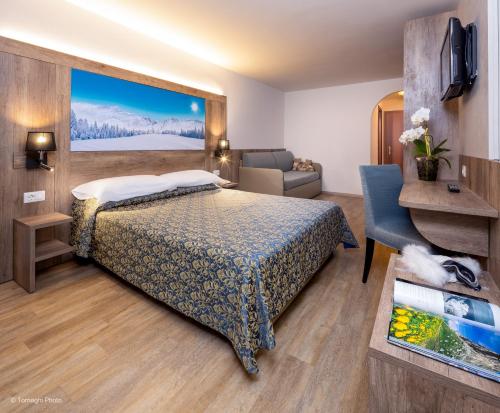 アンダロにあるHotel Alpenのベッドとソファ付きのホテルルーム