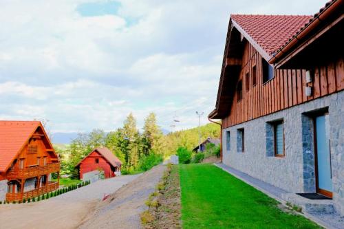 a street in a village with buildings and green grass at Apartmány Valča in Valča