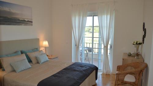 a bedroom with a bed and a sliding glass door at Quinta Formosa Villa in Quinta do Lago