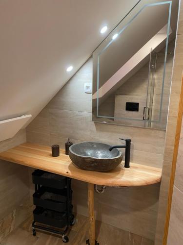 a bathroom with a sink on a wooden counter at Apartma in Bungalov Jezerci in Gozd Martuljek