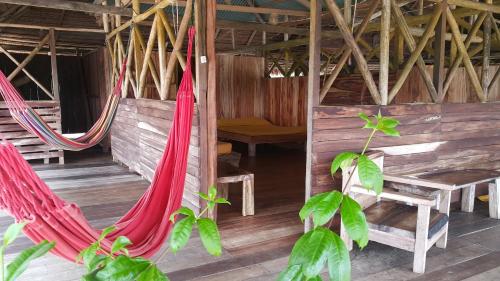 two hammocks in a room with a table and a bench at Cabaña Flotante Kurupira in Leticia