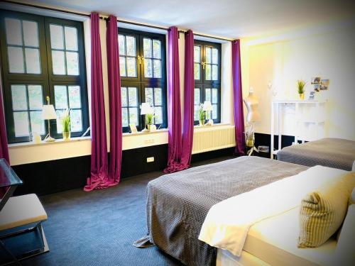 a bedroom with two beds and windows with pink curtains at Sleephotels Suite Garde in Hamburg