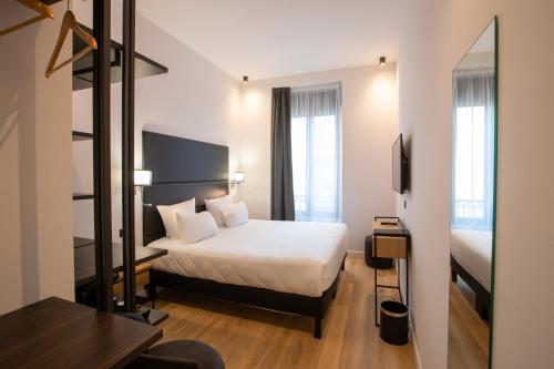 una camera d'albergo con letto e specchio di Hotel Saint Georges a Nizza