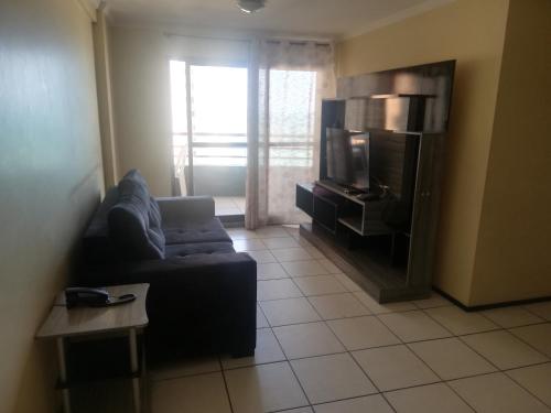 a living room with a couch and a tv at Porto de Iracema Residence in Fortaleza