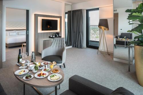 a hotel room with a table with food on it at Meliá Frankfurt City in Frankfurt/Main