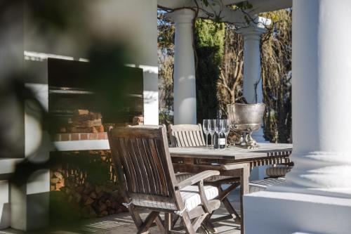 a wooden table and chairs on a patio at Lily Pond House at Le Lude in Franschhoek