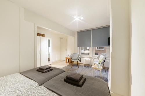 a bedroom with a large bed and a dining room at Adam's Suite in Amsterdam
