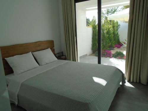 a bedroom with a bed and a large window at ASTERIAS Apartment in Kallithea Halkidikis