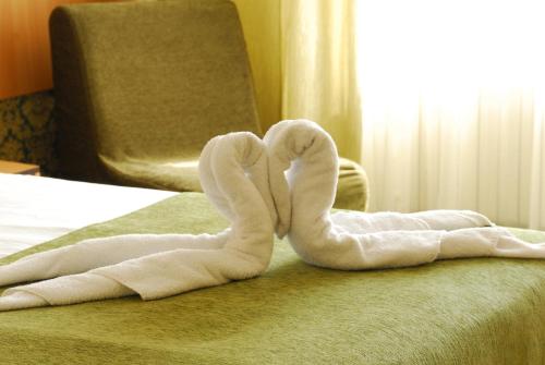 two towels shaped like swans sitting on a bed at Noviz Hotel in Plovdiv