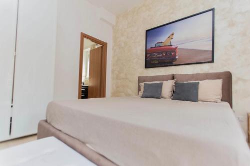 a bedroom with a large white bed with a tv on the wall at San Pietro Home in Rome