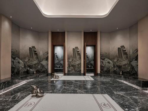 um lobby com um grande piso de mármore com plantas nas paredes em NG Phaselis Bay em Kemer