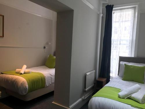 a bedroom with two beds with green and white at Pearl & Pebbles Eastbourne in Eastbourne
