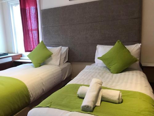 two beds in a room with green and white at Pearl & Pebbles Eastbourne in Eastbourne