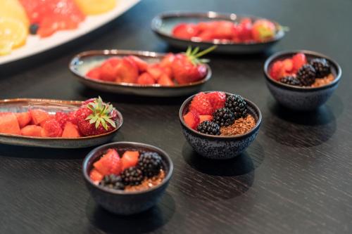a group of bowls of fruit on a table at Meliá Frankfurt City in Frankfurt/Main