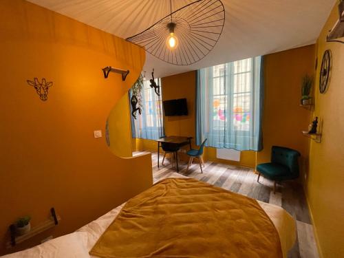 JuNgLe ROOM في رومان-سور-إيزير: غرفة نوم بسرير وطاولة وكراسي