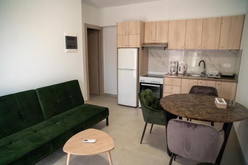 a living room with a green couch and a table at Hello Village Chania in SFakianalíon