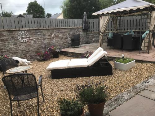 a backyard with a couch and a gazebo at Sound of the River in Talgarth