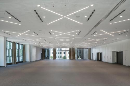 an empty room with white ceilings and windows at Meliá Frankfurt City in Frankfurt/Main