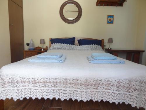 a bedroom with a bed with white sheets and a mirror at Casa D'armaros in Kissamos