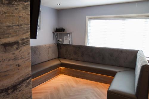 a couch sitting in a room with a window at 19 Rodney Street Apartments in Liverpool