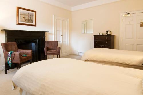 a bedroom with two beds and a fireplace at Rydal Hall Christian Retreat Centre in Rydal