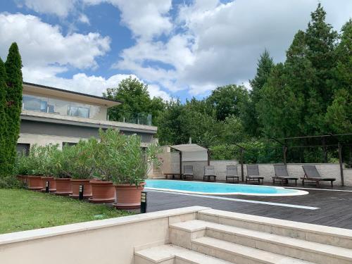 a backyard with a swimming pool and patio furniture at White Luxury Villa Esztergom in Esztergom