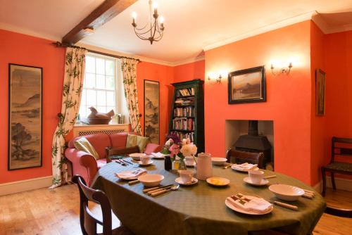 een woonkamer met een tafel en een open haard bij St Annes Bed and Breakfast in Painswick