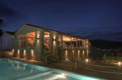 a house with a swimming pool at night at Ntinas Filoxenia Hotel & Spa in Skala Potamias