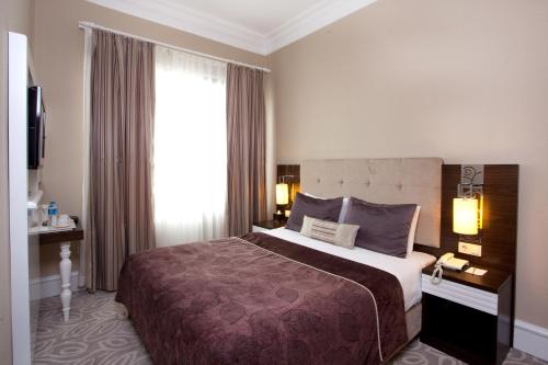 a hotel room with a large bed and a window at City Center Hotel Taksim İstanbul in Istanbul