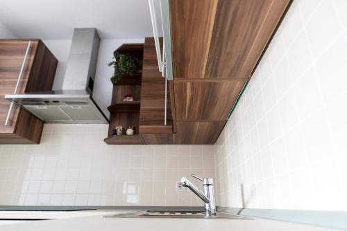 Una cocina con gabinetes de madera y un fregadero. en B8 apartment, en Bohinj
