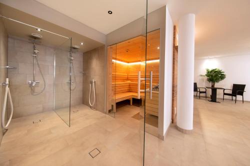 a bathroom with a shower and a sink and a desk at Edelweisshaus Apartments Königsleiten in Königsleiten