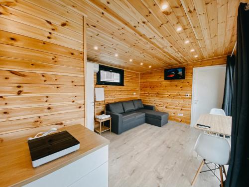 a living room with a couch and wooden walls at Pixel - Tiny Campus in Tîrgu Secuiesc