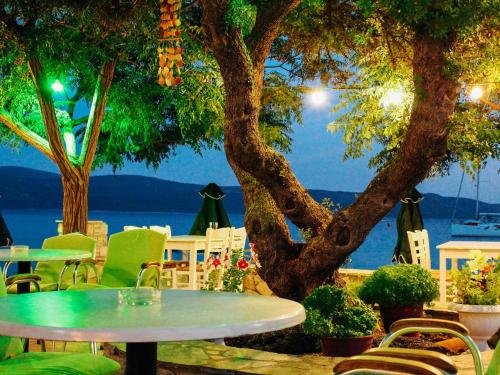 a table and chairs and a tree with a view of the water at Klima Paradise in Klíma