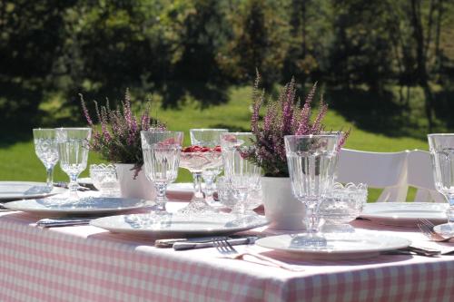 a table with glasses and plates on a table at Villa Sofia Boutique Trakai in Trakai