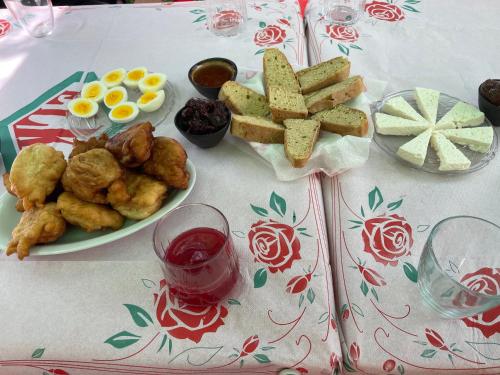a table with a plate of food with eggs and bread at The White Villa in Bogovë