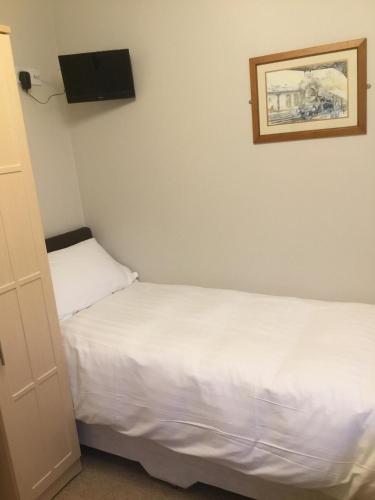a bedroom with two beds and a tv on the wall at The Loco in Haxey